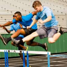 Students jumping track hurdles